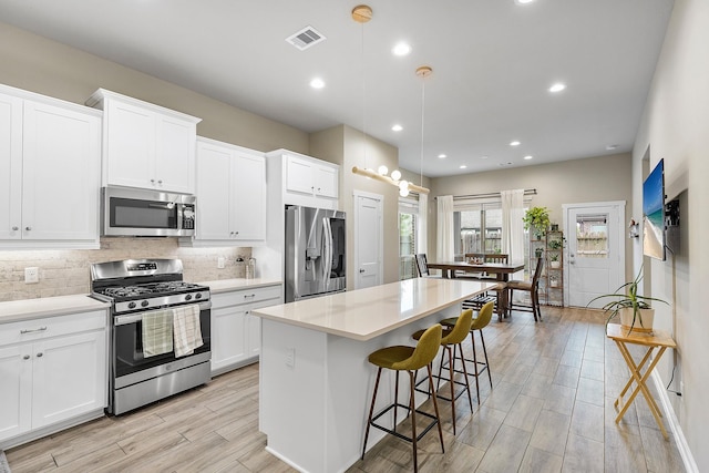 kitchen with white cabinets, a center island, and stainless steel appliances