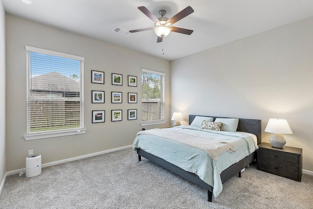 carpeted bedroom featuring multiple windows and ceiling fan