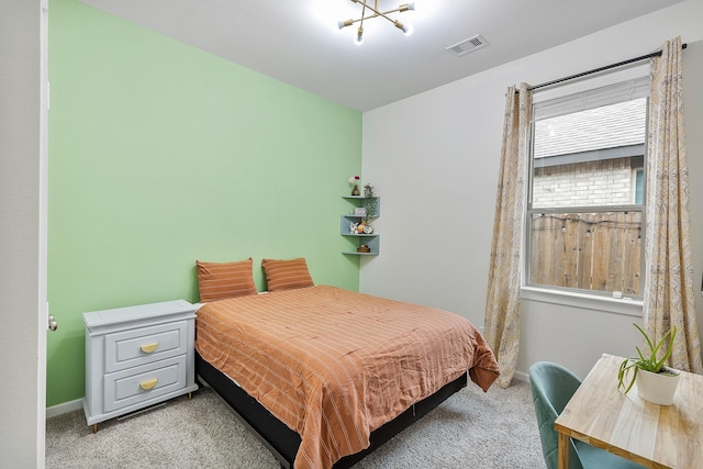 bedroom with light colored carpet and a chandelier