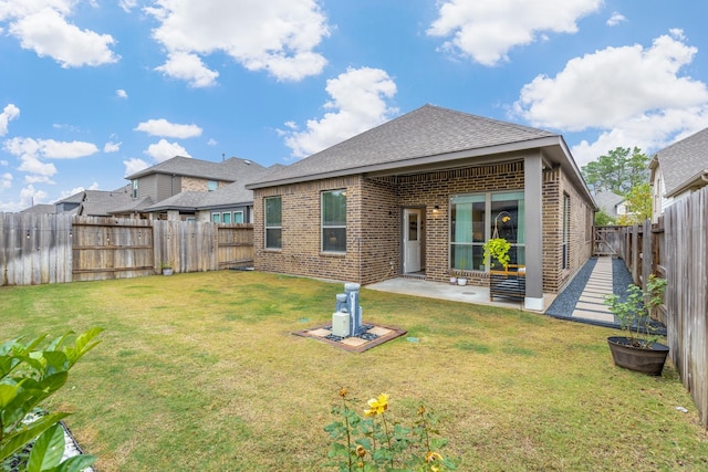 rear view of house with a yard and a patio