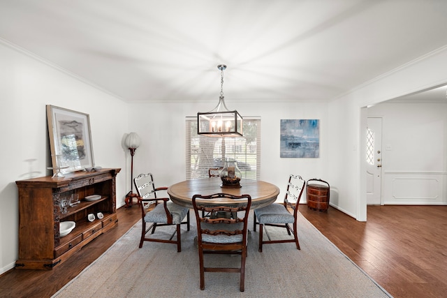 dining room with dark hardwood / wood-style flooring, a chandelier, and ornamental molding