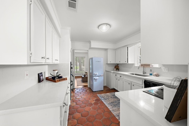 kitchen featuring white cabinets, crown molding, and white fridge