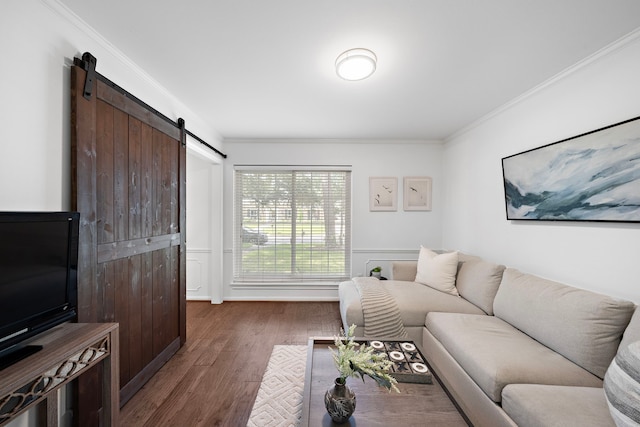 living room with a barn door, dark hardwood / wood-style floors, and crown molding