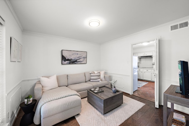 living room with dark hardwood / wood-style flooring and crown molding