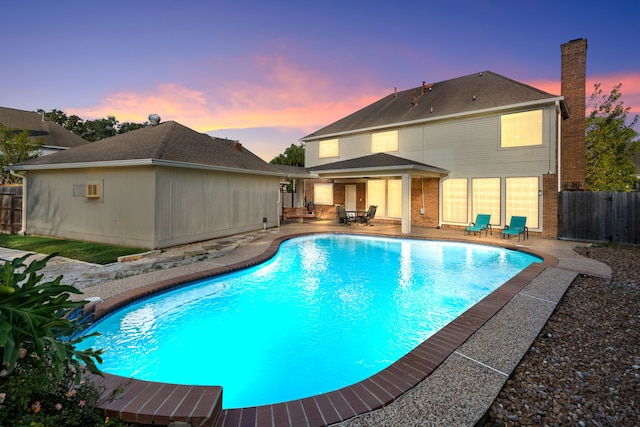 pool at dusk with a patio