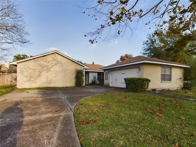 ranch-style house featuring a garage and a front lawn