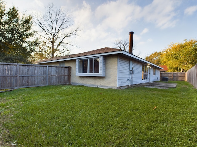 rear view of property with central AC, a yard, and a patio