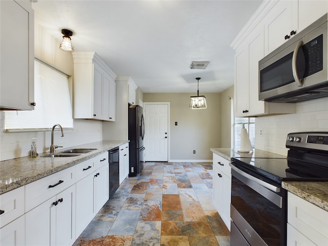 kitchen featuring black appliances, decorative light fixtures, white cabinets, and sink