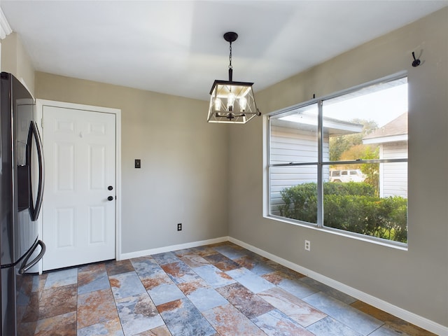 unfurnished dining area with a chandelier