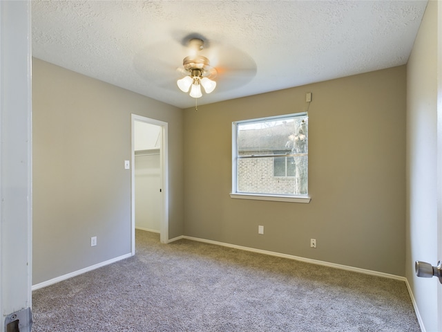 unfurnished room featuring carpet flooring and a textured ceiling