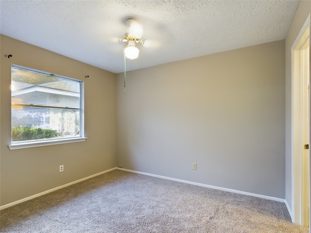 unfurnished room with ceiling fan, light colored carpet, and a textured ceiling