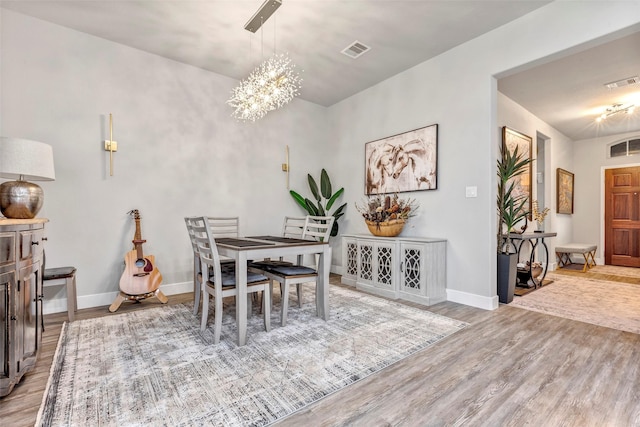 dining area featuring a chandelier and light wood-type flooring