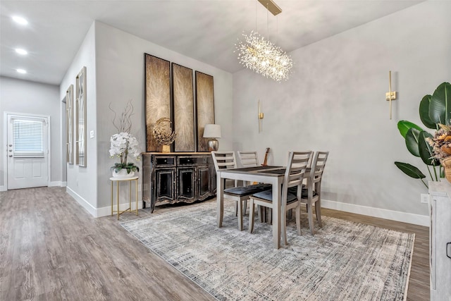 dining area with hardwood / wood-style floors and a chandelier