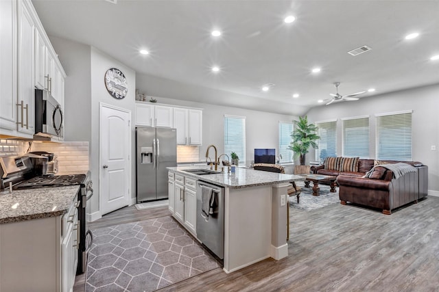 kitchen featuring white cabinetry, sink, an island with sink, and appliances with stainless steel finishes