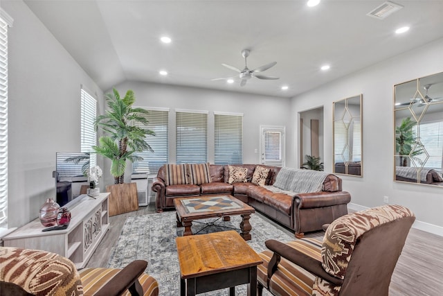 living room with lofted ceiling, ceiling fan, and light wood-type flooring