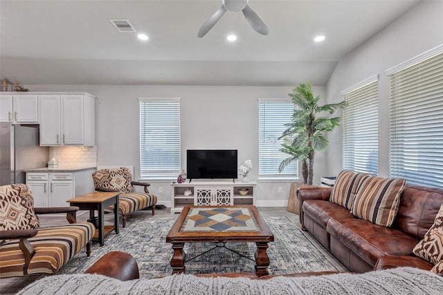 living room featuring ceiling fan, vaulted ceiling, and hardwood / wood-style flooring