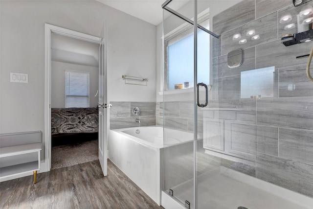 bathroom with hardwood / wood-style flooring and separate shower and tub