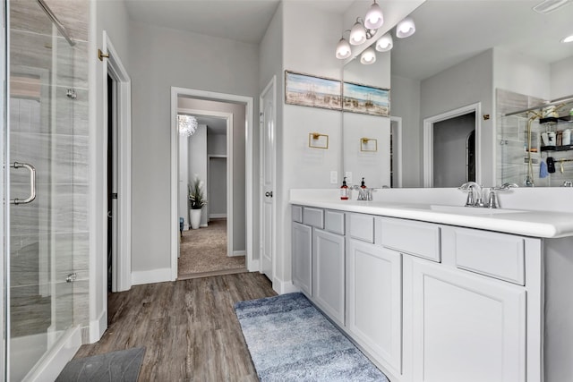 bathroom with hardwood / wood-style flooring, vanity, and walk in shower