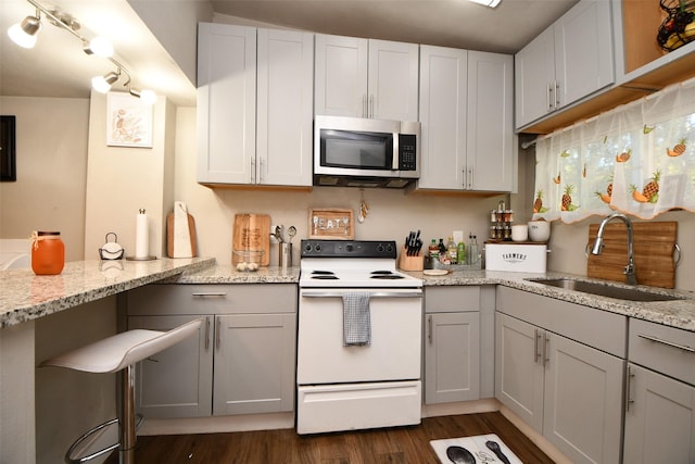 kitchen featuring white cabinetry, sink, light stone counters, and white range with electric stovetop