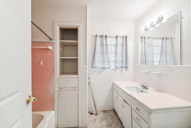 bathroom with tile patterned flooring, vanity, tub / shower combination, and tile walls