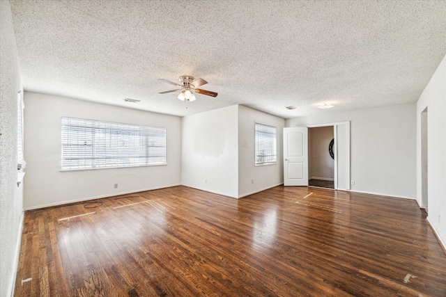 empty room featuring dark hardwood / wood-style floors, ceiling fan, and a textured ceiling