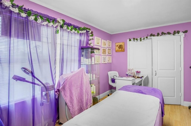 bedroom with light hardwood / wood-style floors and crown molding