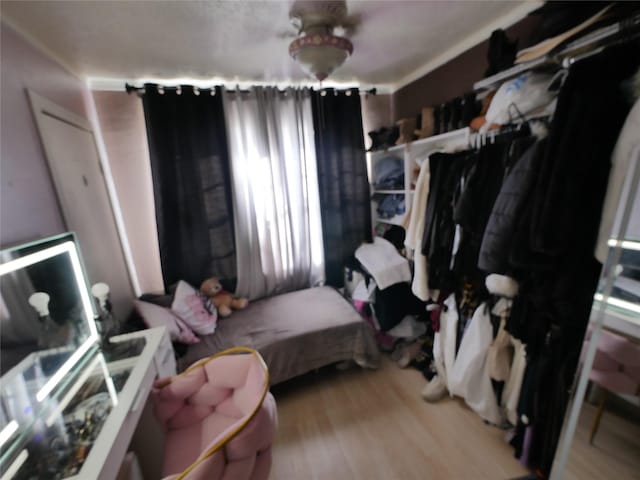 bedroom featuring ornamental molding and light hardwood / wood-style flooring