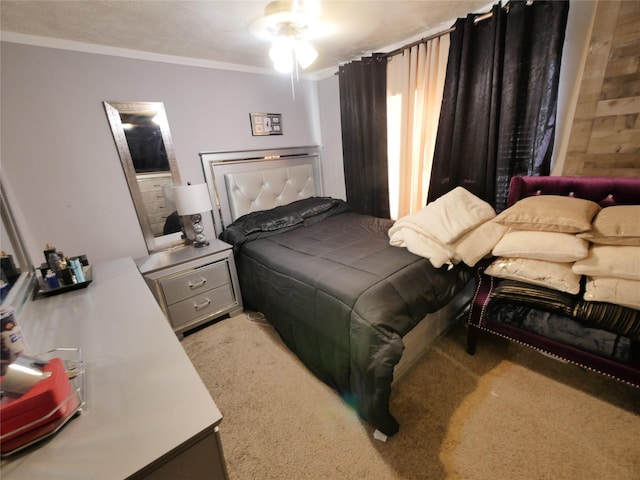 bedroom with light carpet, a textured ceiling, ceiling fan, and ornamental molding