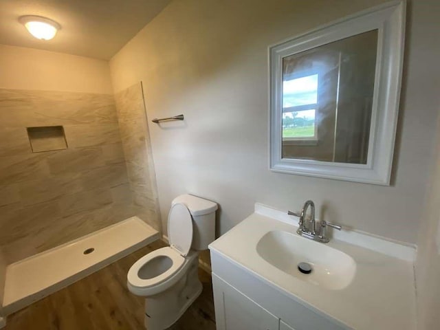 bathroom featuring a shower, vanity, and toilet