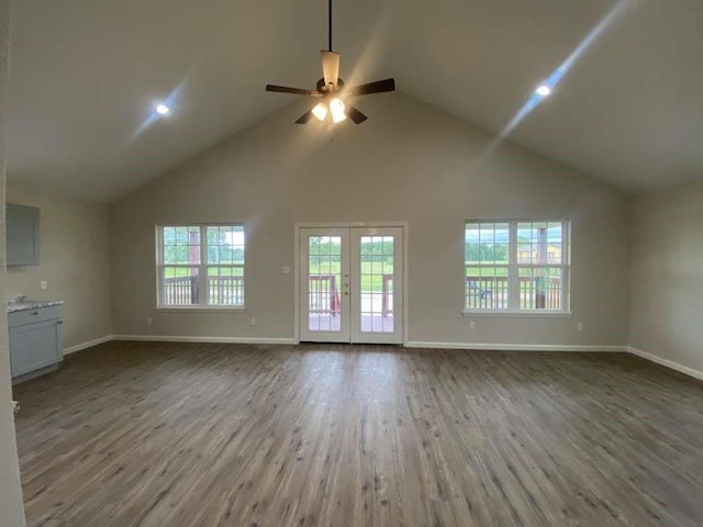 unfurnished living room with ceiling fan, french doors, high vaulted ceiling, and wood-type flooring