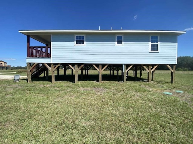 back of house featuring a wooden deck and a yard