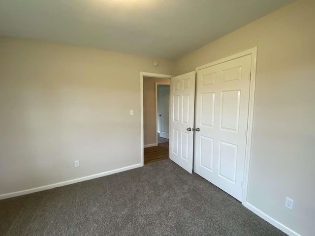 unfurnished bedroom with dark colored carpet