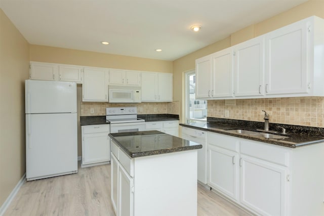 kitchen with sink, a kitchen island, white appliances, white cabinets, and light wood-type flooring