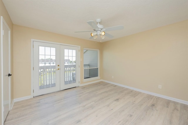 empty room featuring ceiling fan, light hardwood / wood-style floors, a textured ceiling, and french doors