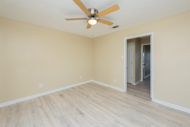 empty room featuring a textured ceiling, light hardwood / wood-style floors, and ceiling fan