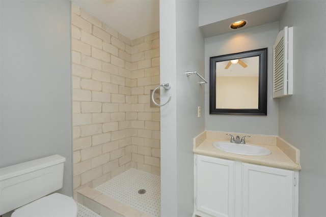 bathroom featuring tiled shower, vanity, and toilet