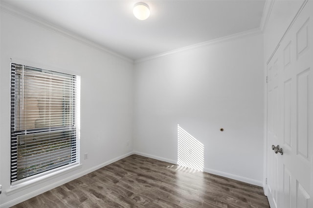 spare room with dark hardwood / wood-style flooring and crown molding