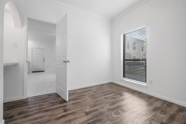 spare room with crown molding and dark wood-type flooring