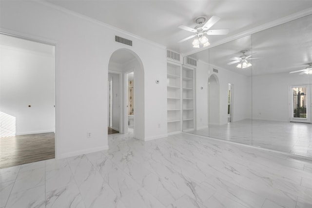 empty room featuring built in features, ceiling fan, and ornamental molding