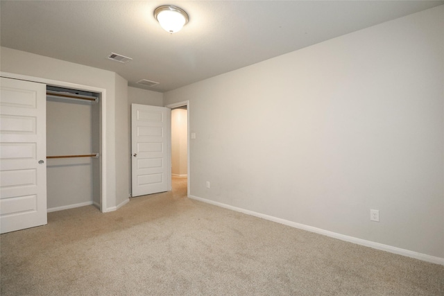 unfurnished bedroom with light carpet and a closet