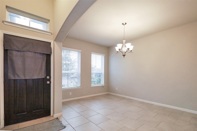 foyer with a chandelier and light tile patterned flooring