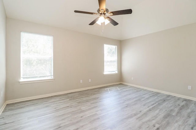 empty room featuring ceiling fan, light wood-type flooring, and a wealth of natural light