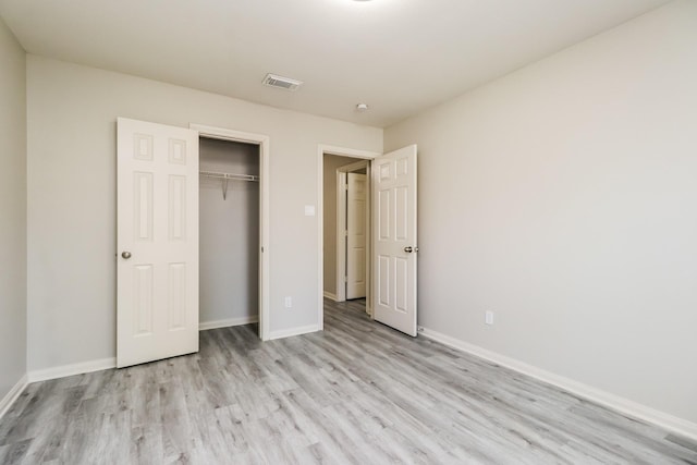 unfurnished bedroom with light hardwood / wood-style flooring and a closet