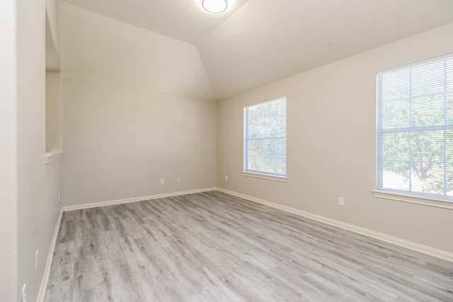 unfurnished room with light wood-type flooring and vaulted ceiling