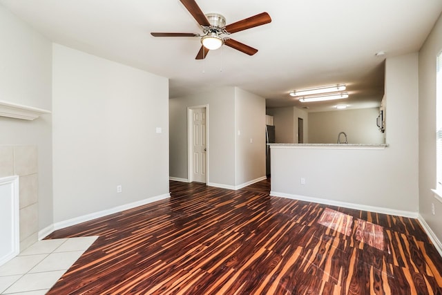 unfurnished living room featuring ceiling fan, wood-type flooring, and sink