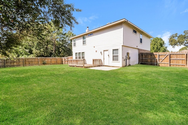 back of house with a yard, a patio, and a wooden deck