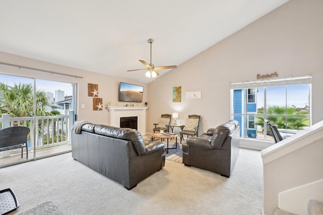 living room with plenty of natural light, ceiling fan, light carpet, and high vaulted ceiling