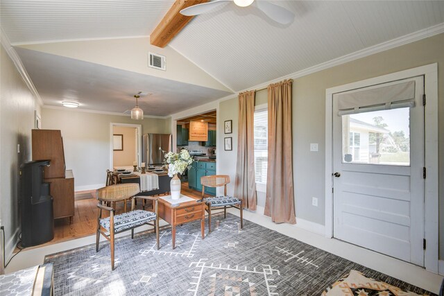 entrance foyer featuring hardwood / wood-style floors, lofted ceiling with beams, ceiling fan, and ornamental molding