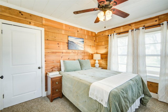 bedroom featuring ceiling fan, crown molding, carpet floors, and wooden walls