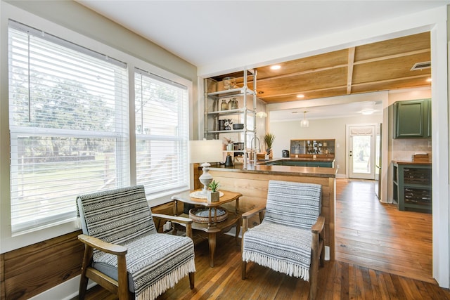 sitting room featuring beam ceiling and dark hardwood / wood-style floors